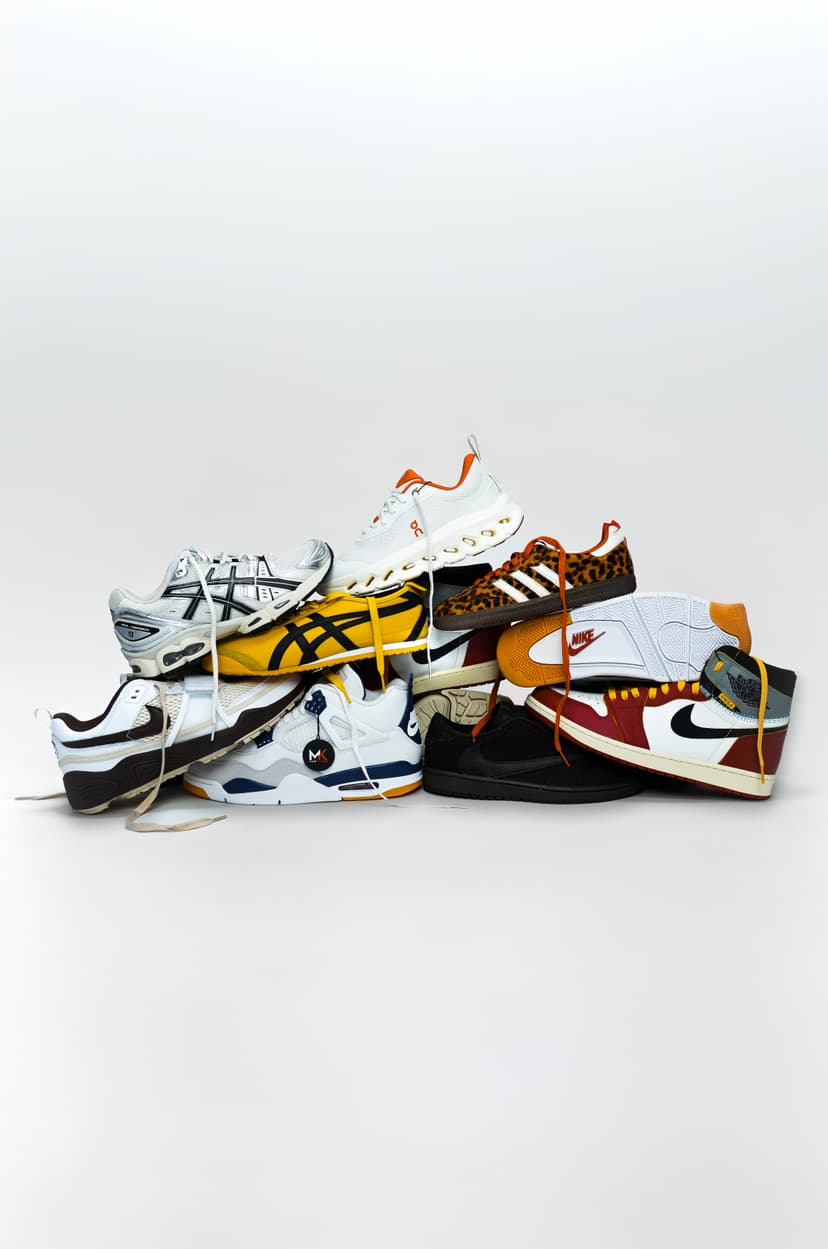 A stack of colorful, assorted sneakers with various designs, including animal prints, stripes, and logos, against a plain white background.